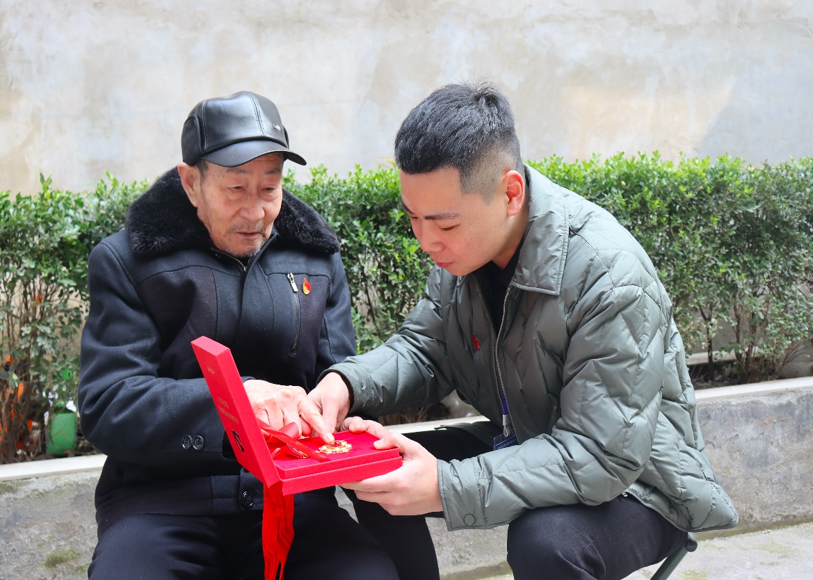 老黨員金知一展示“光榮在黨50年”紀念章 